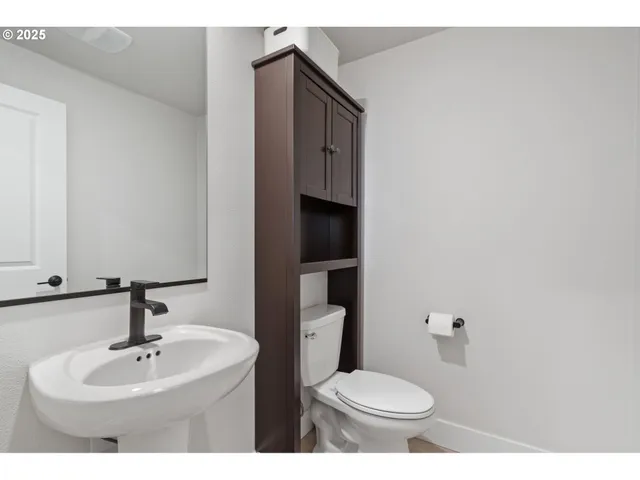 a bathroom with a toilet sink and mirror