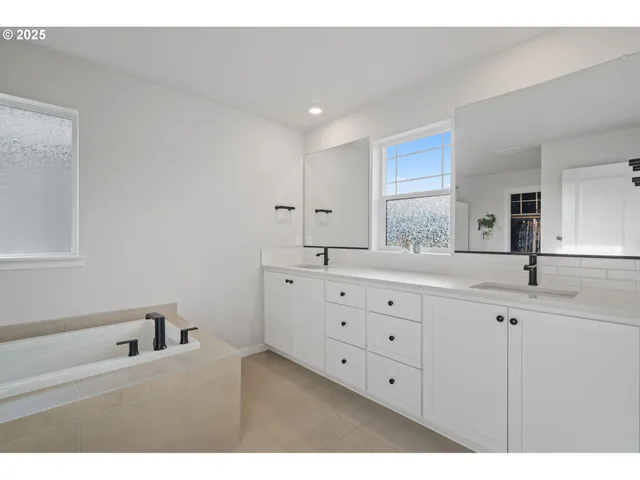 a bathroom with a double vanity sink and mirror with window