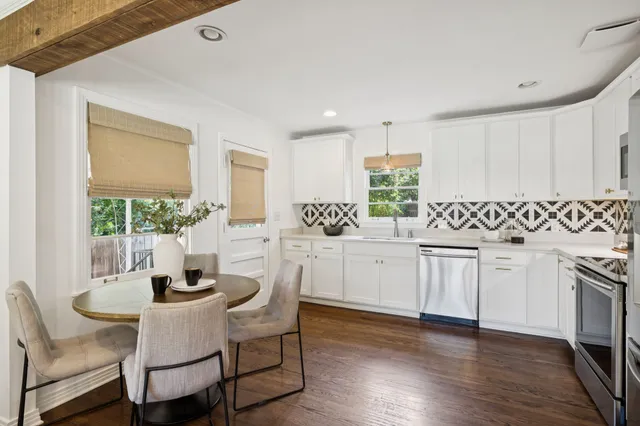 a kitchen with white cabinets a sink and a stove