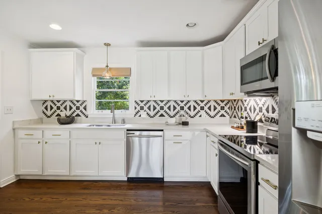 a kitchen with stainless steel appliances a sink a stove a microwave a sink and cabinets