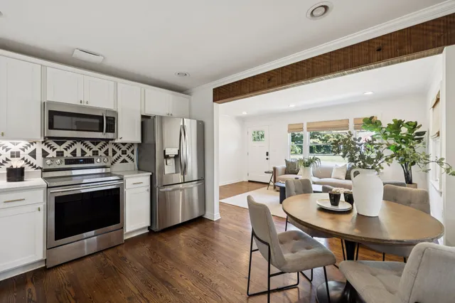 a kitchen with a table chairs refrigerator and microwave