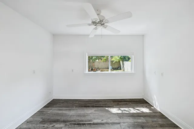 an empty room with a window and a ceiling fan