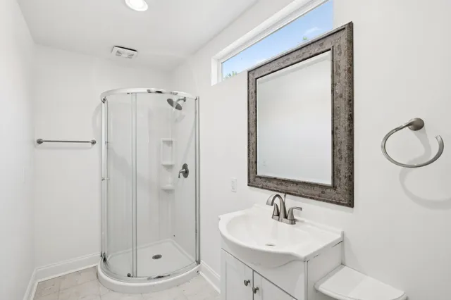 a bathroom with a sink a toilet and shower