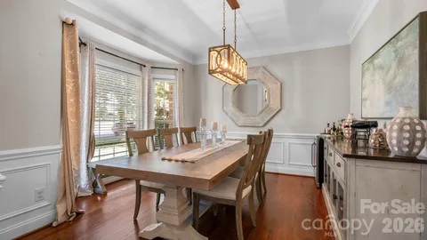 a view of a hallway with wooden floor and chandelier