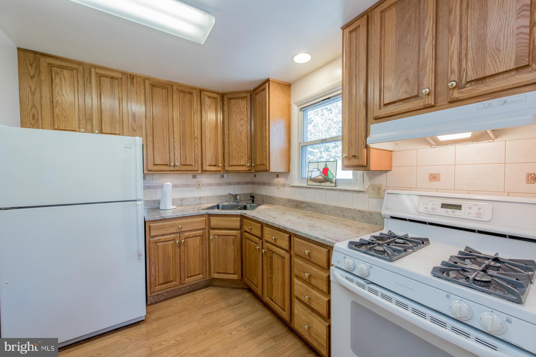 107 Ridgely Road Glen Burnie, MD 21061 - Photo 3 of 22 a kitchen with a sink a stove cabinets and a refrigerator