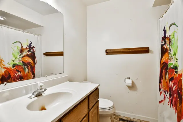 a bathroom with a sink and mirror with toilet