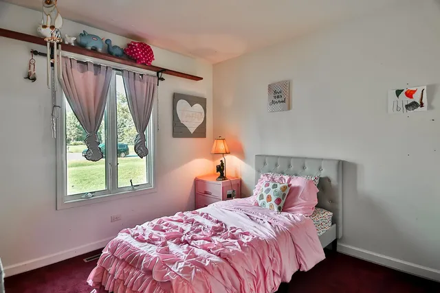 a bedroom with a bed a window and a mirror