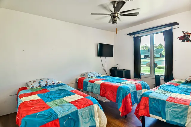 a bedroom with two bed and a window