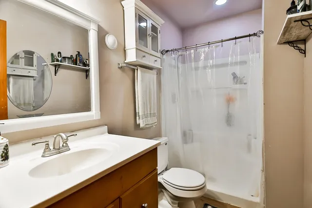 a bathroom with a sink vanity mirror and toilet