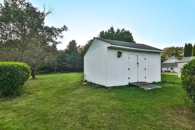 a white house with a small yard and wooden fence