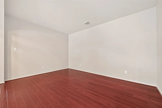 a view of a room with wooden floor chandelier and a window