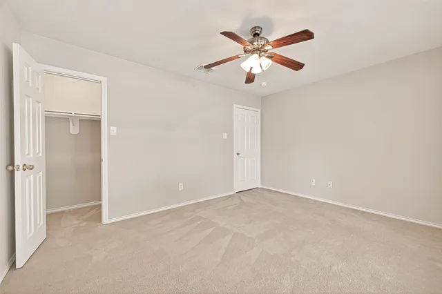 an empty room with closet and windows