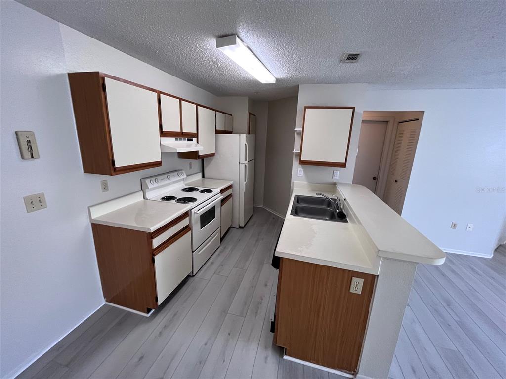 623 Dory Lane, Unit 210 Altamonte Springs, FL 32714 - Photo 4 of 12 a kitchen with sink a microwave a stove and cabinets