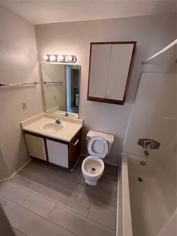 a bathroom with a sink toilet and mirror