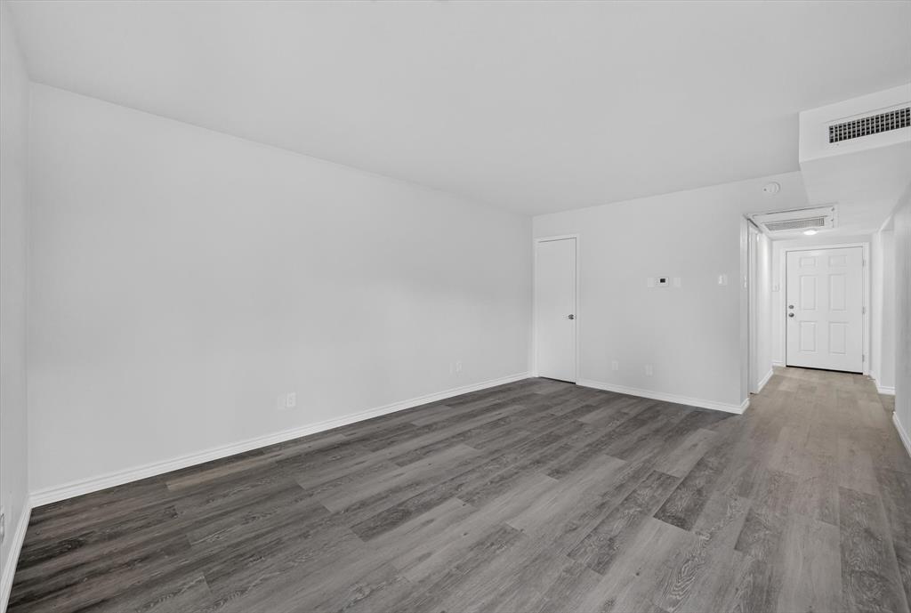 1801 East Grauwyler Road, Unit 101 Irving, TX 75061 - Photo 8 of 39 a view of an empty room with wooden floor and a window