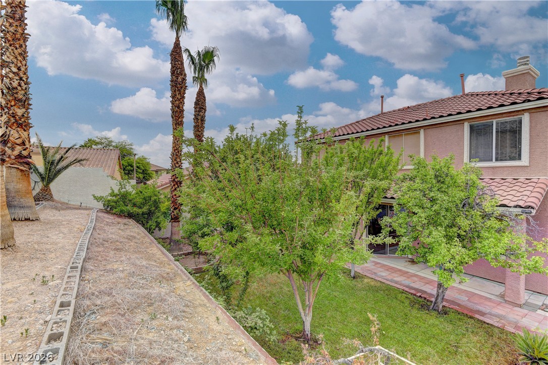 1813 Snow Spring Lane Las Vegas, NV 89134 - Photo 35 of 37 Discover a spacious backyard with lush landscaping, perfect for private relaxation and outdoor enjoyment.