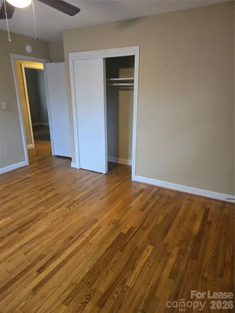 an empty room with wooden floor and closet