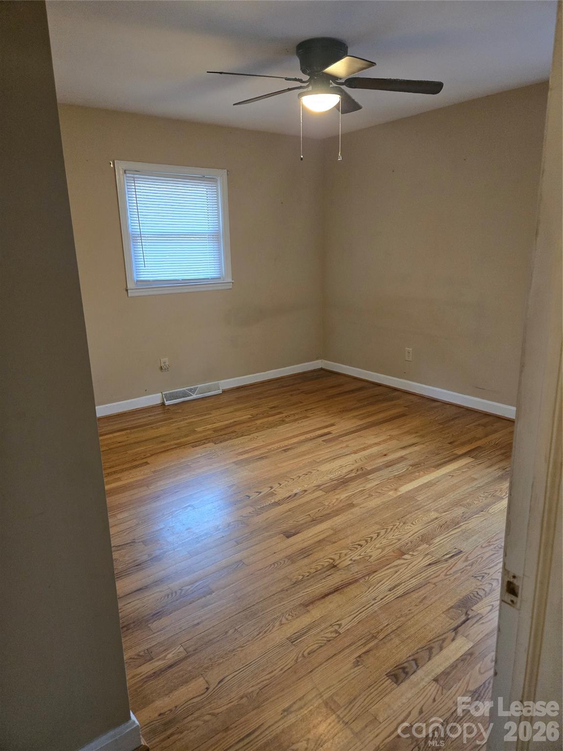 158 Crestview Street Rutherfordton, NC 28139 - Photo 14 of 15 an empty room with wooden floor fan and window