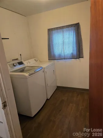 a utility room with wooden floor washer and dryer