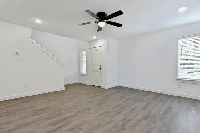 an empty room with fan and windows