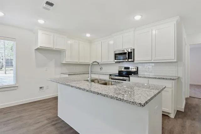 a kitchen with granite countertop a sink and a stove top oven