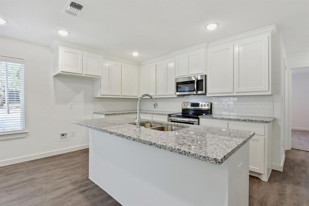 103 East Bond Street Denison, TX 75021 - Photo 8 of 21 a kitchen with granite countertop a sink and a stove top oven