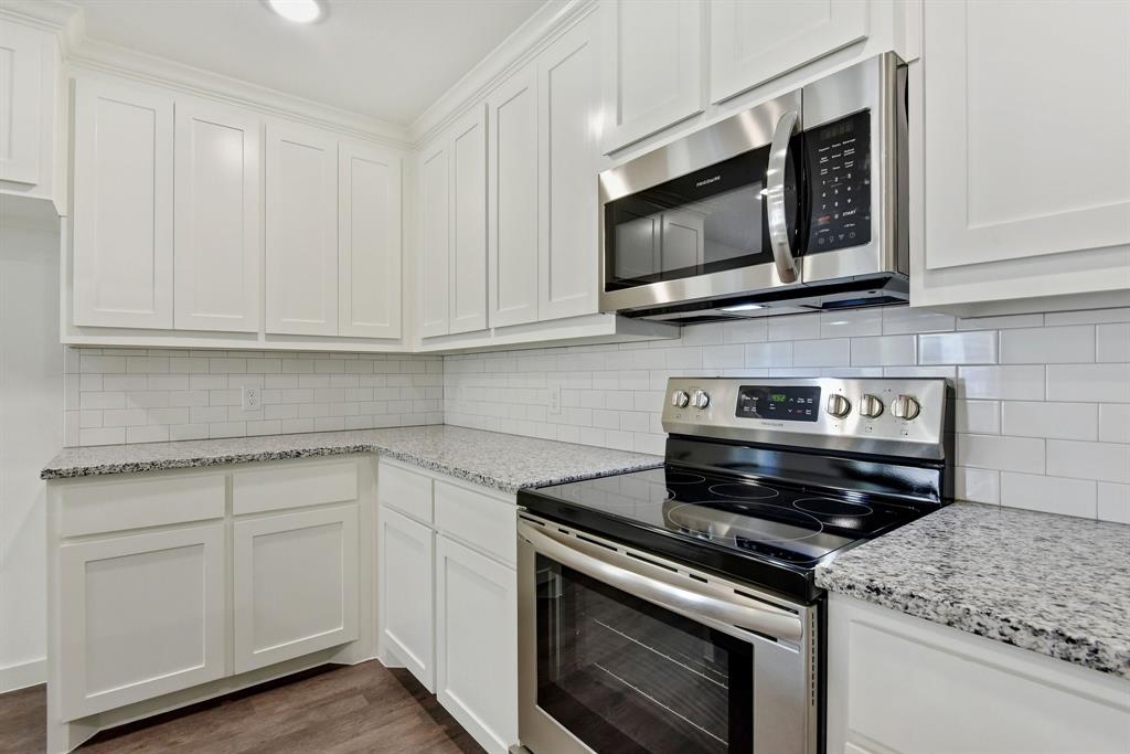 103 East Bond Street Denison, TX 75021 - Photo 9 of 21 a kitchen with stainless steel appliances granite countertop grey cabinets and a stove top oven
