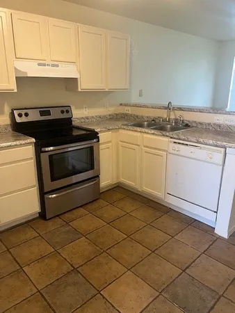 a kitchen with granite countertop cabinets stainless steel appliances and a sink