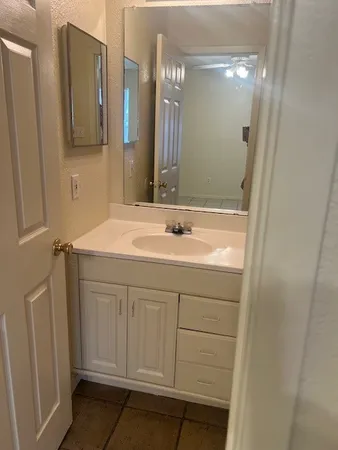 a bathroom with a sink vanity and a mirror