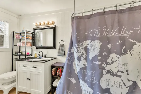 a bathroom with a bathtub sink vanity mirror and toilet