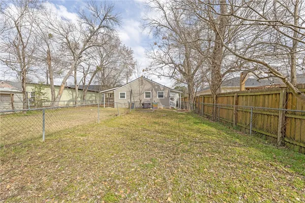 a view of a yard with wooden fence