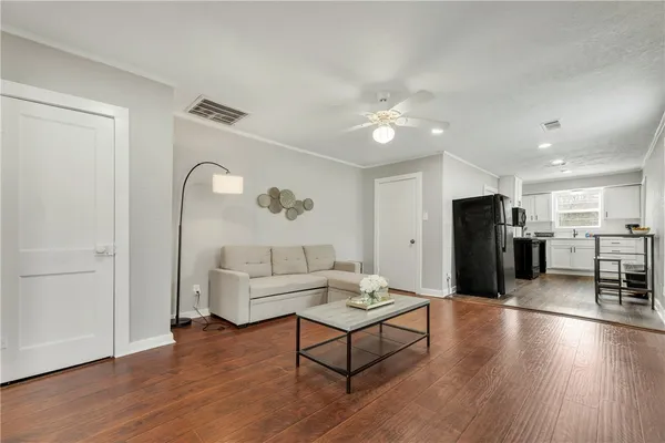 a living room with furniture and wooden floor