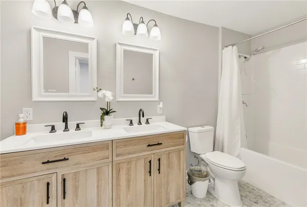 a bathroom with a sink vanity mirror and toilet