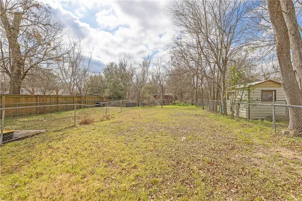 a view of yard with swimming pool and trees in the background
