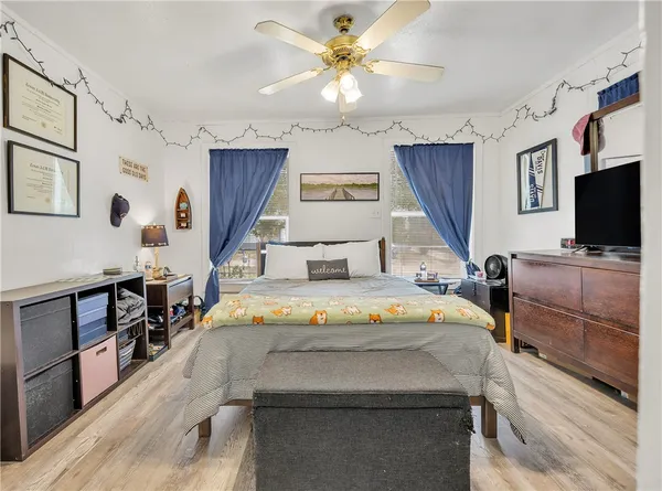 a bedroom with a bed and a flat tv screen on dresser