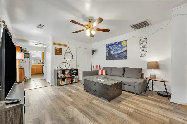 a living room with furniture a flat screen tv and a table
