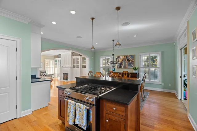 a kitchen with stainless steel appliances granite countertop a stove and a view of living room