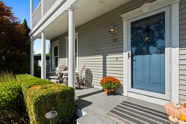a view of a porch with furniture and floor to ceiling window and potted plants