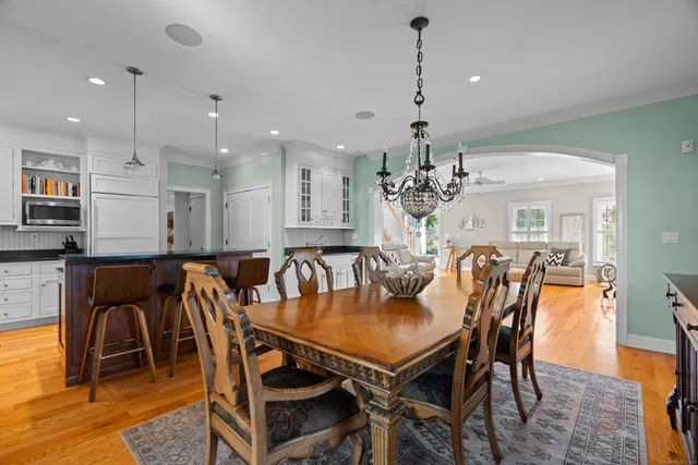 a view of a dining room and livingroom with furniture wooden floor a chandelier