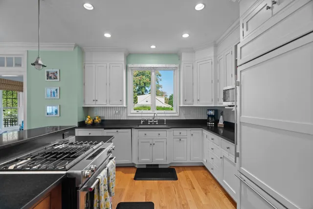 a kitchen with granite countertop a sink a stove and cabinets