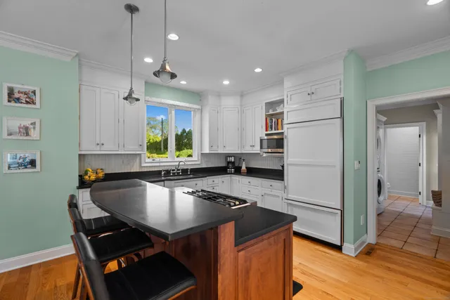 a kitchen with kitchen island a sink appliances and cabinets