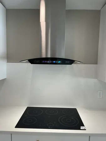 a kitchen with stainless steel appliances white cabinets a sink and a window