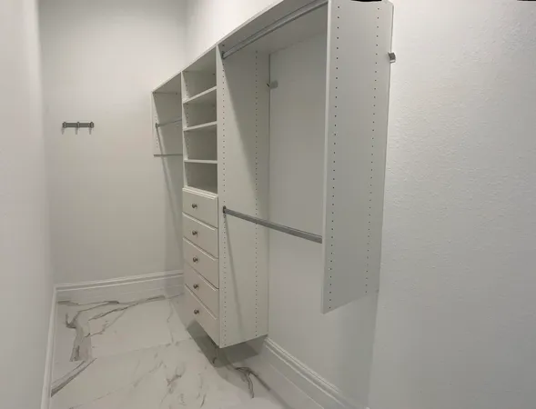 a view of walk in closet with empty racks