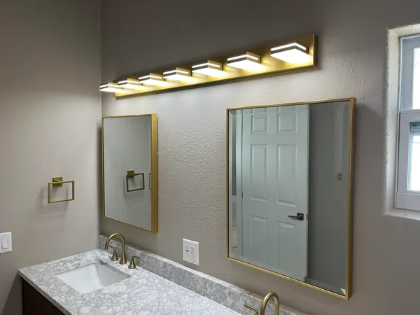 a bathroom with a granite countertop sink and a mirror