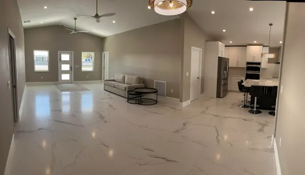 a kitchen with stainless steel appliances kitchen island granite countertop a sink refrigerator and cabinets