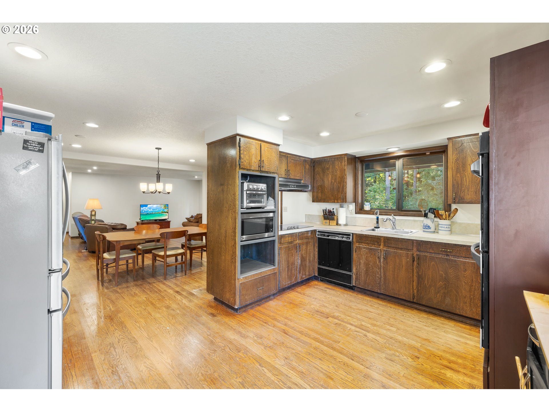 18489 South Ferguson Road Oregon City, OR 97045 - Photo 11 of 39 a kitchen with stainless steel appliances kitchen island granite countertop a refrigerator a sink a stove and oven with wooden floor