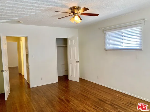 a view of room with hardwood floor and a ceiling fan