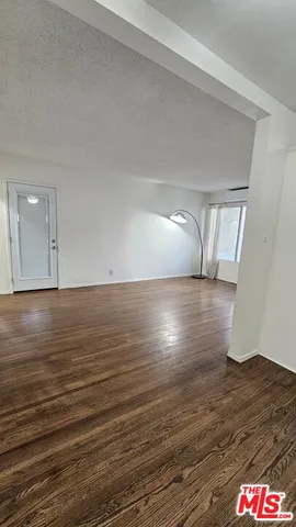 a kitchen with wooden floors and refrigerator