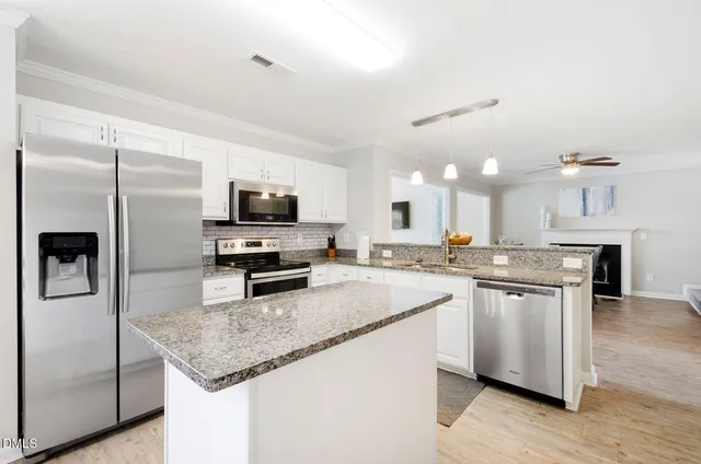 a kitchen with stainless steel appliances granite countertop a sink refrigerator and microwave