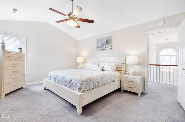 a spacious bedroom with a bed and a chandelier